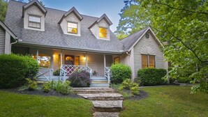 A two-story house with a porch, a stone pathway leading to the entrance, and a well-maintained lawn. - Spacious 5BR Helen villa with private pool, hot tub, and game room. (Helen)