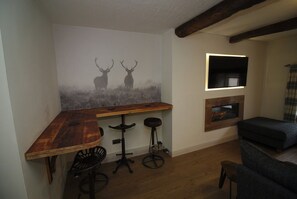 Relax in a cozy room with a rustic bar, comfortable seating area, and a fireplace.