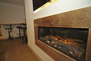 Cozy up by the fireplace in this inviting space, complete with a comfortable seating area.