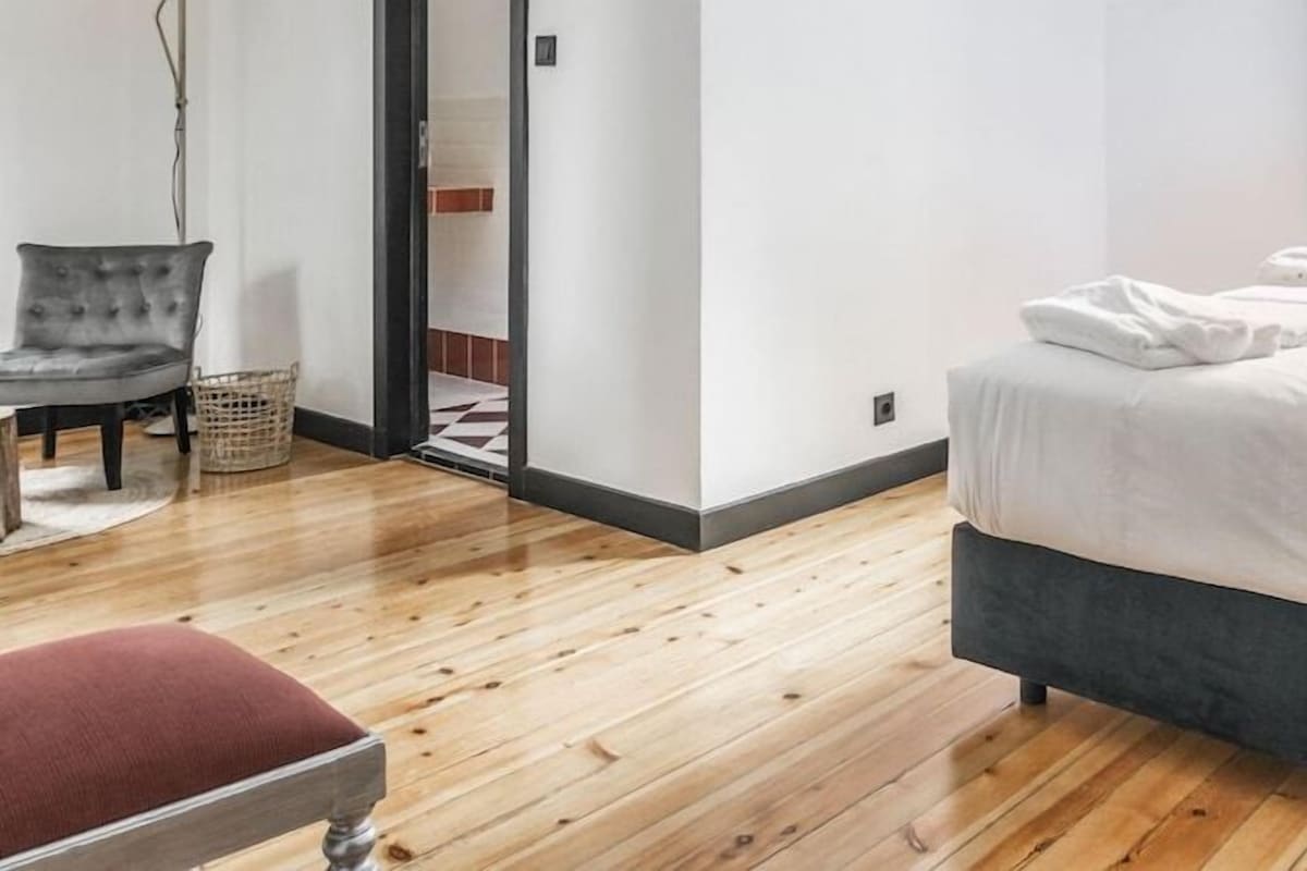Une chambre à coucher avec un lit, une chaise et une fenêtre.