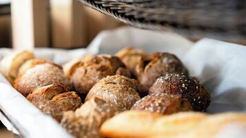 Une assiette contenant un assortiment de petits pains, certains parsemés de graines de sésame et d’autres de graines de pavot.