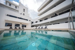 Piscine couverte, piscine extérieure, parasols de plage, chaises longues