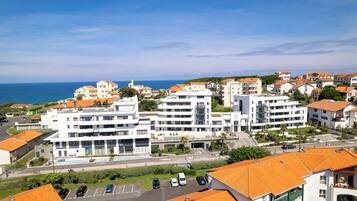Un hotel frente al mar con varios pisos, piscina y vistas al océano.