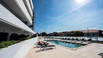 Piscine couverte, piscine extérieure, parasols de plage, chaises longues