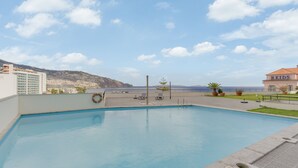A swimming pool with a view of a cityscape and mountains in the background. - Funchal View Apartment (Funchal)