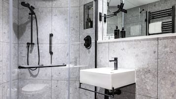 A modern bathroom with a shower, a sink, and a mirror.