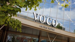 The exterior of the Voco An IHG Hotel with a modern glass facade and a clear view of the sky reflected in the windows. - voco Leicester by IHG (Leicester)