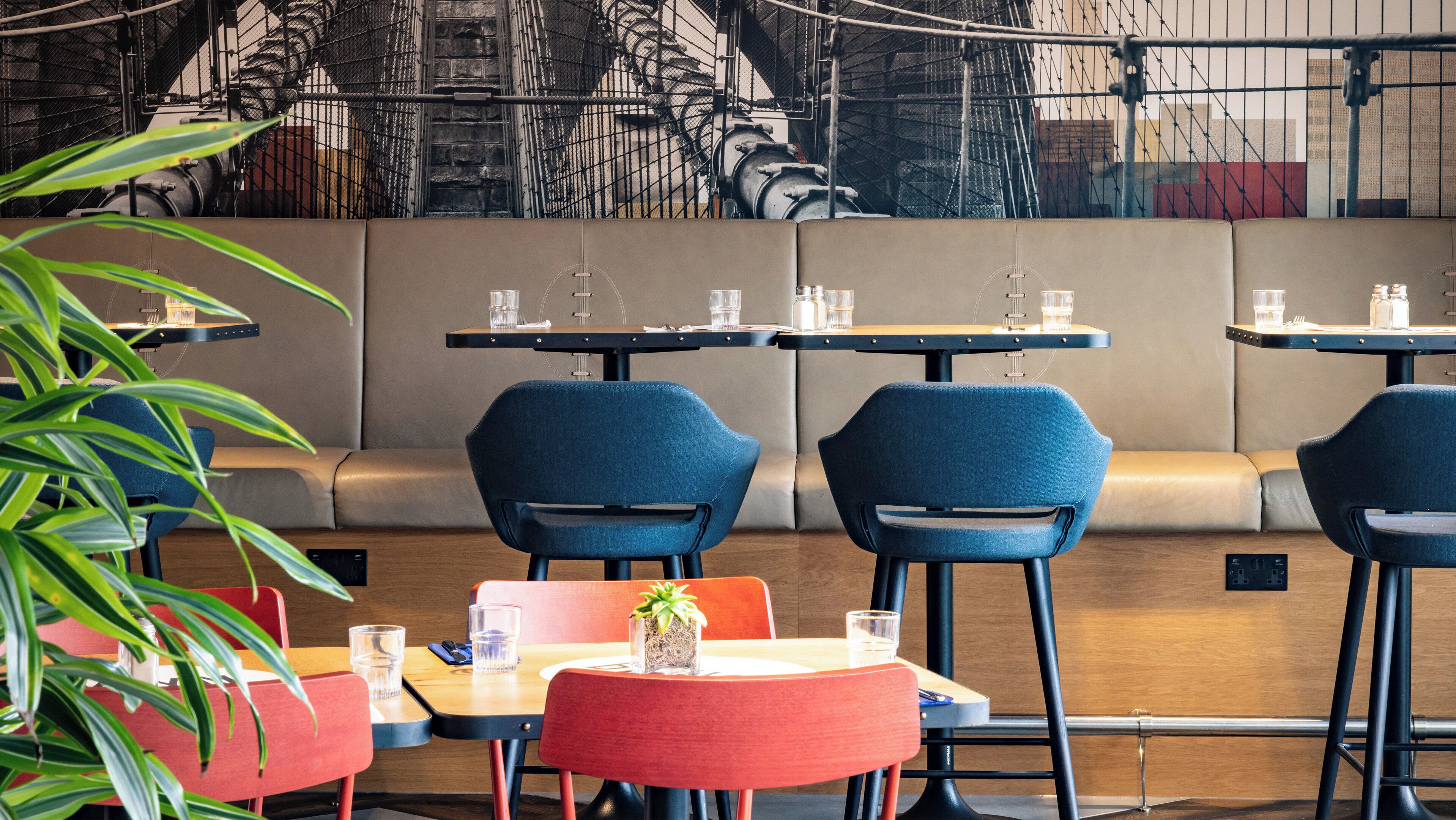 A restaurant with booths and tables, some with plants.