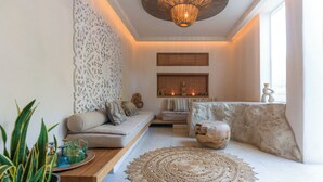 Un soggiorno moderno con divano, parete decorativa e una grande lampada in fibra.