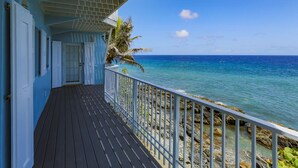 A wooden deck with a white railing overlooking a rocky shoreline and clear blue ocean. - Cliffside at Cane Bay - 3 bed/ 4 bath seaside home with private pool. (Cane Bay beach)