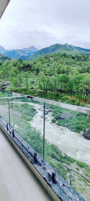 Un río con un puente, rodeado de vegetación y montañas.
