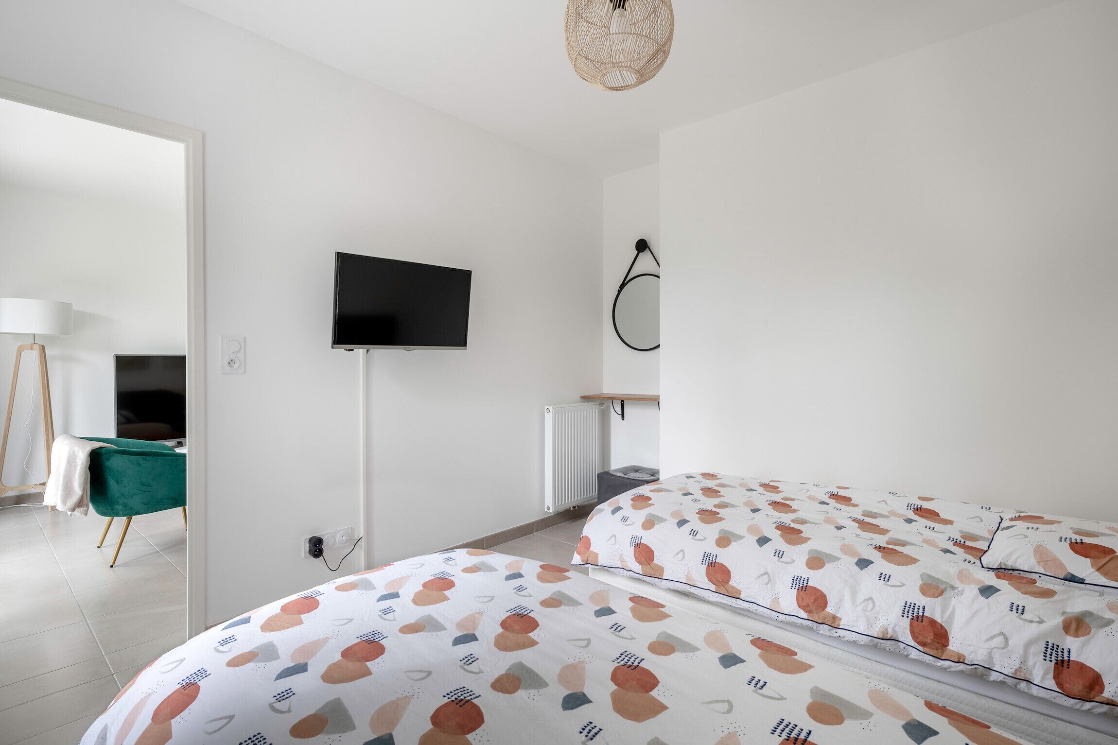 A modern bedroom with a bed, a TV, and a radiator.