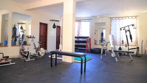 A gym with exercise equipment, a bench, and a mirror. - Stay.Plus Mtwapa Luxe Apartments (Mtwapa)