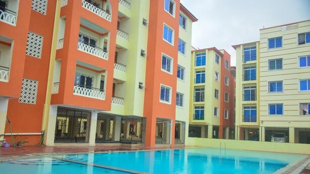 A swimming pool surrounded by multi-story buildings with balconies. - Stay.Plus Mtwapa Luxe Apartments (Mtwapa)