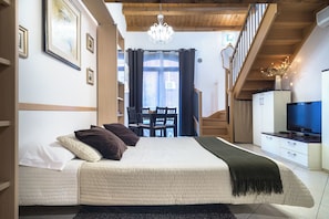 A bedroom with a bed, a TV, a staircase, and a view of the outside. - Duplex: spacious apartment with terrace and air conditioning at the entrance of Venice. (Venezia)