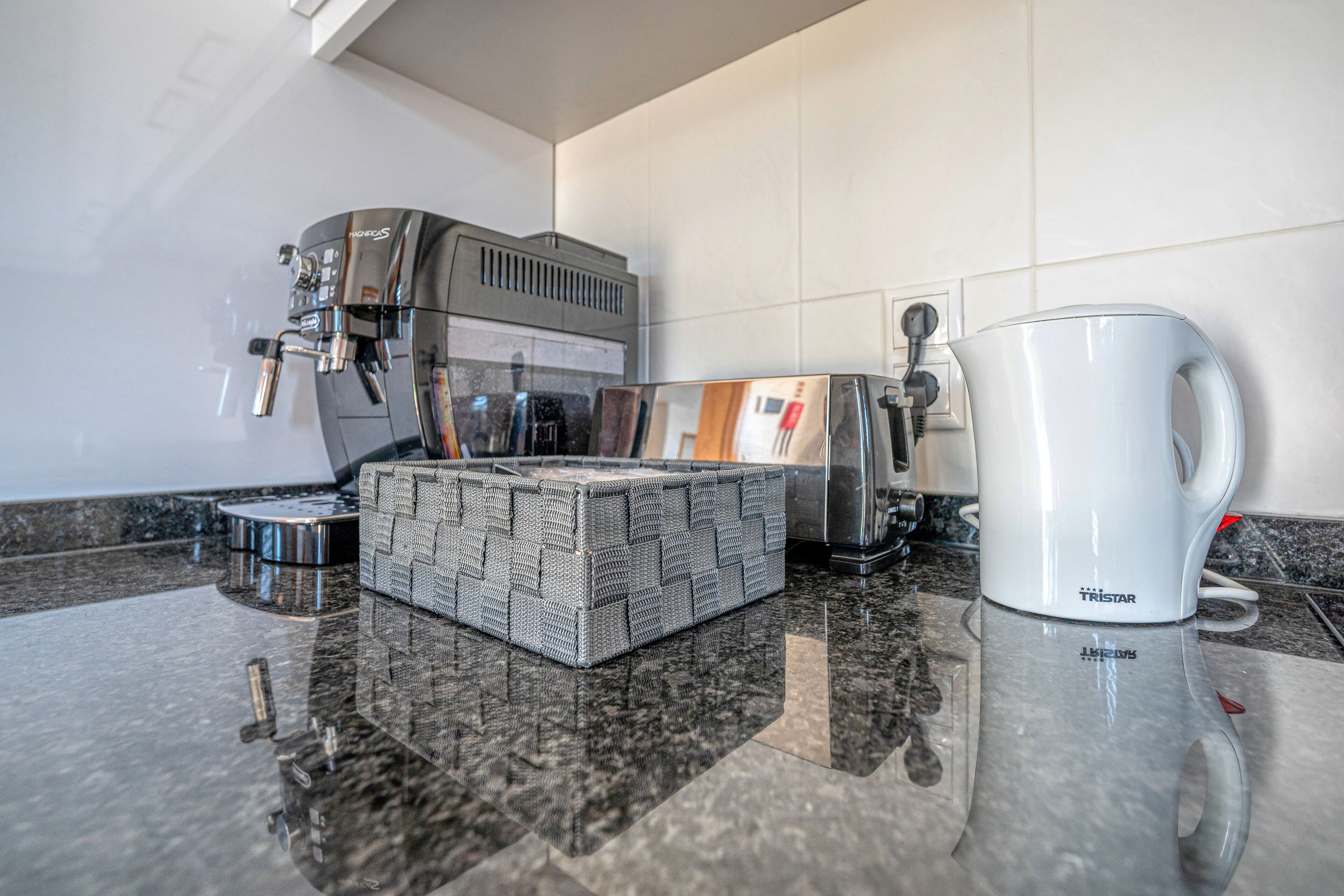 Un coin cuisine équipé d’une machine à café, d’une cafetière et d’un plateau.