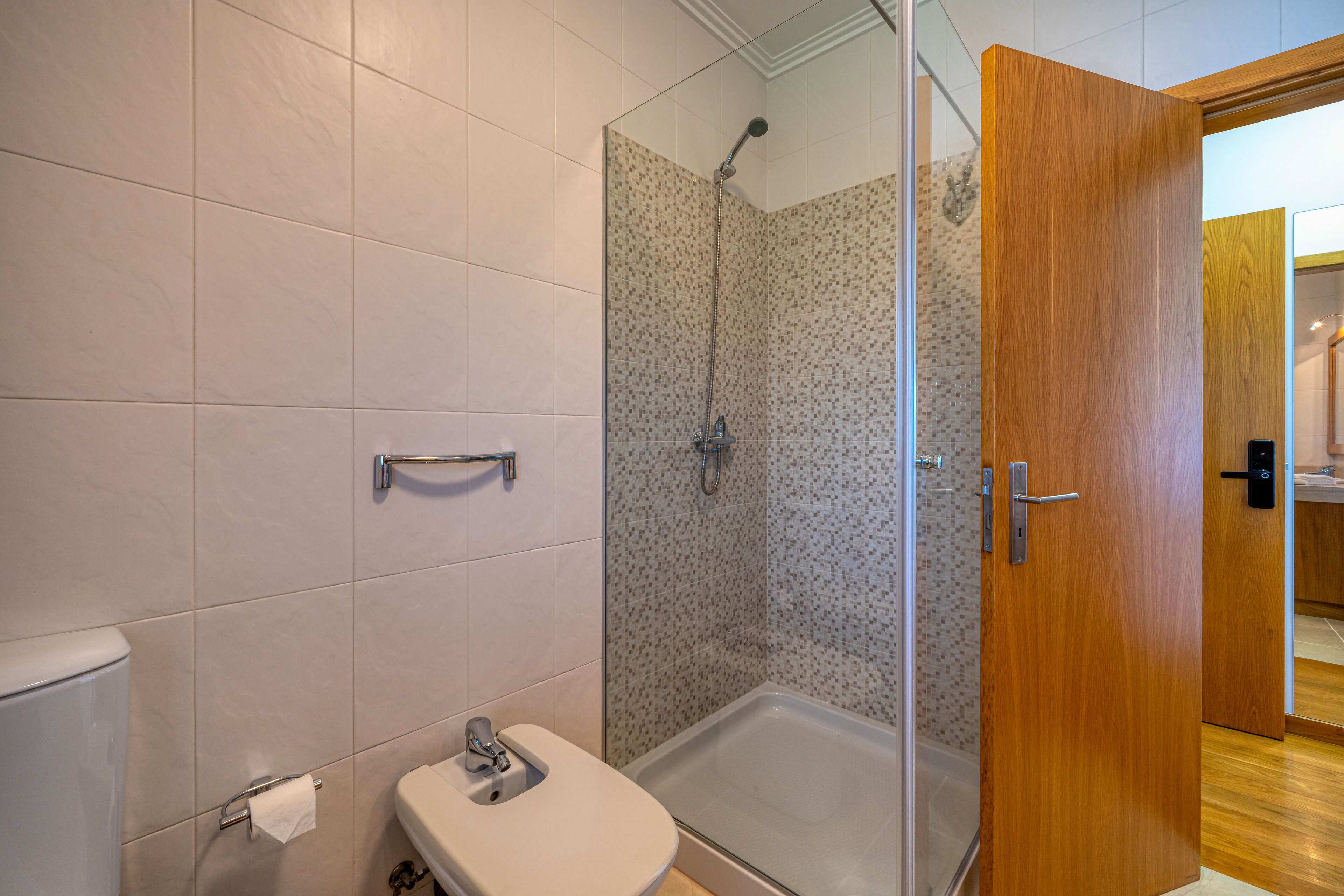 Une salle de bain avec douche, toilettes et lavabo.