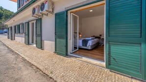 A hotel room with a bed, a desk, and a window. - Central Suites Arouca (Arouca)
