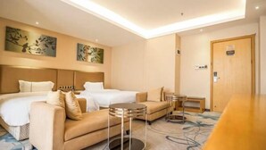 A hotel room with two beds, a sofa, a small table, and artwork on the walls. - Jiayu Business Hostel (Sihui)