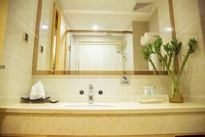 A bathroom with a sink, mirror, and a plant. - Jiayu Business Hostel (Sihui)