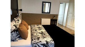 Un dormitorio con una cama, una mesita de noche, un espejo y un radiador.