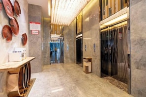 A hotel lobby with a marble floor, a reception desk, and an elevator. - Lidu Hotel (Shaodong)