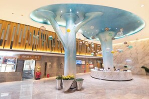 A modern lobby with a unique tree-like structure, a reception desk, and a marble floor. - Lidu Hotel (Shaodong)