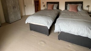 A bedroom with two beds, a wardrobe, a door leading to a closet, and a ceiling with recessed lighting. - Monthly, Short, Stays 2-bed Apartment in Reading (Reading)