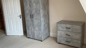 A room with a large wardrobe, a smaller chest of drawers, and a white door. - Monthly, Short, Stays 2-bed Apartment in Reading (Reading)