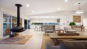 Cozy living space with a fireplace, comfortable seating, and a central kitchen island.