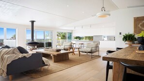 Enjoy a spacious living area with a high ceiling, large windows, and a comfortable seating arrangement.
