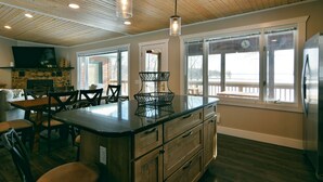 Una cocina con armarios de madera, una isla central e iluminación colgante.