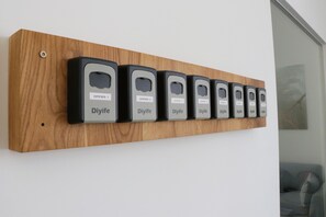 Un panel de madera con seis dispositivos negros etiquetados como "Diyife" y "ZIMMER" sobre una pared blanca.