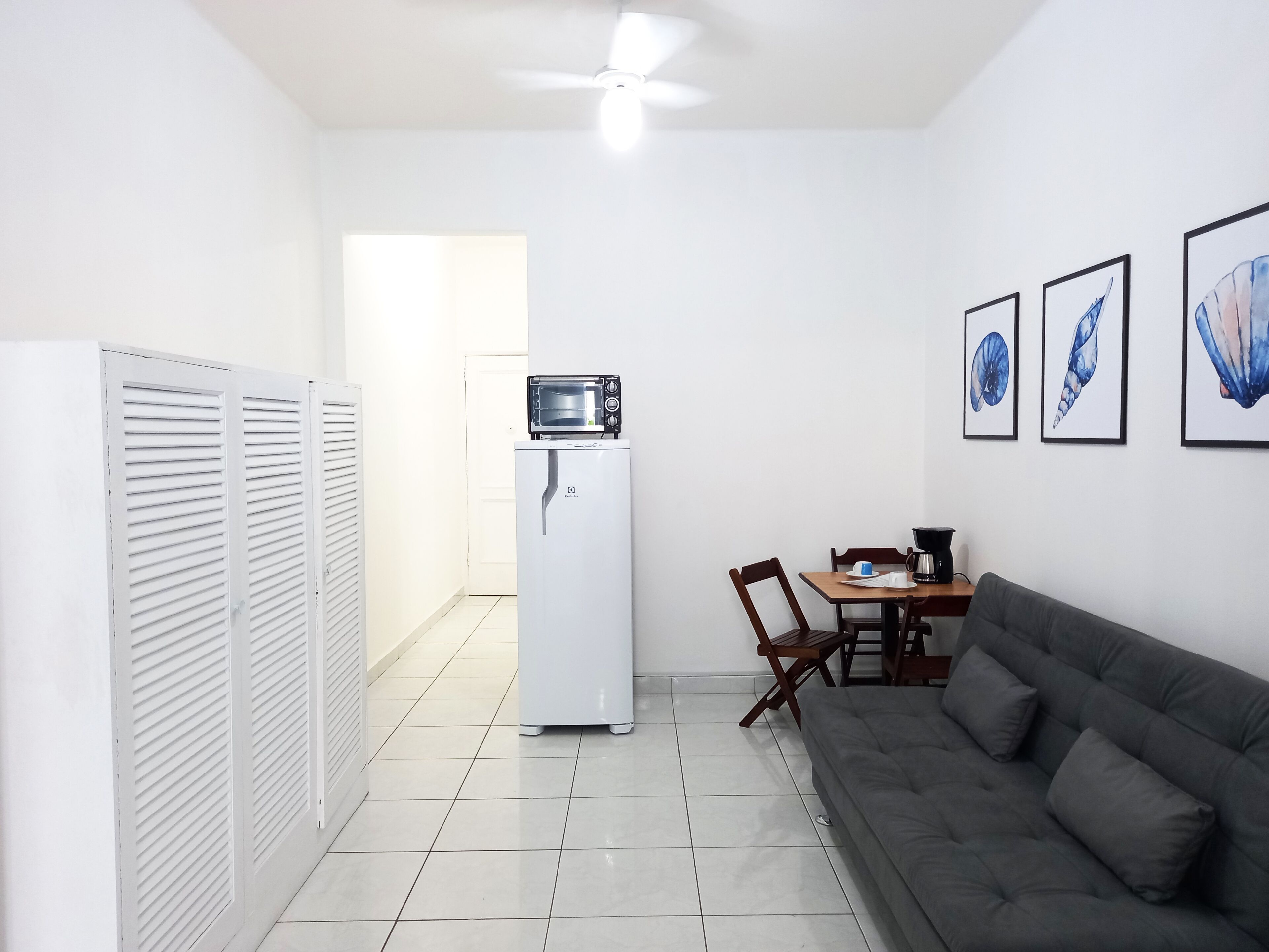 A compact living space with a kitchenette, a dining area, and a sofa.