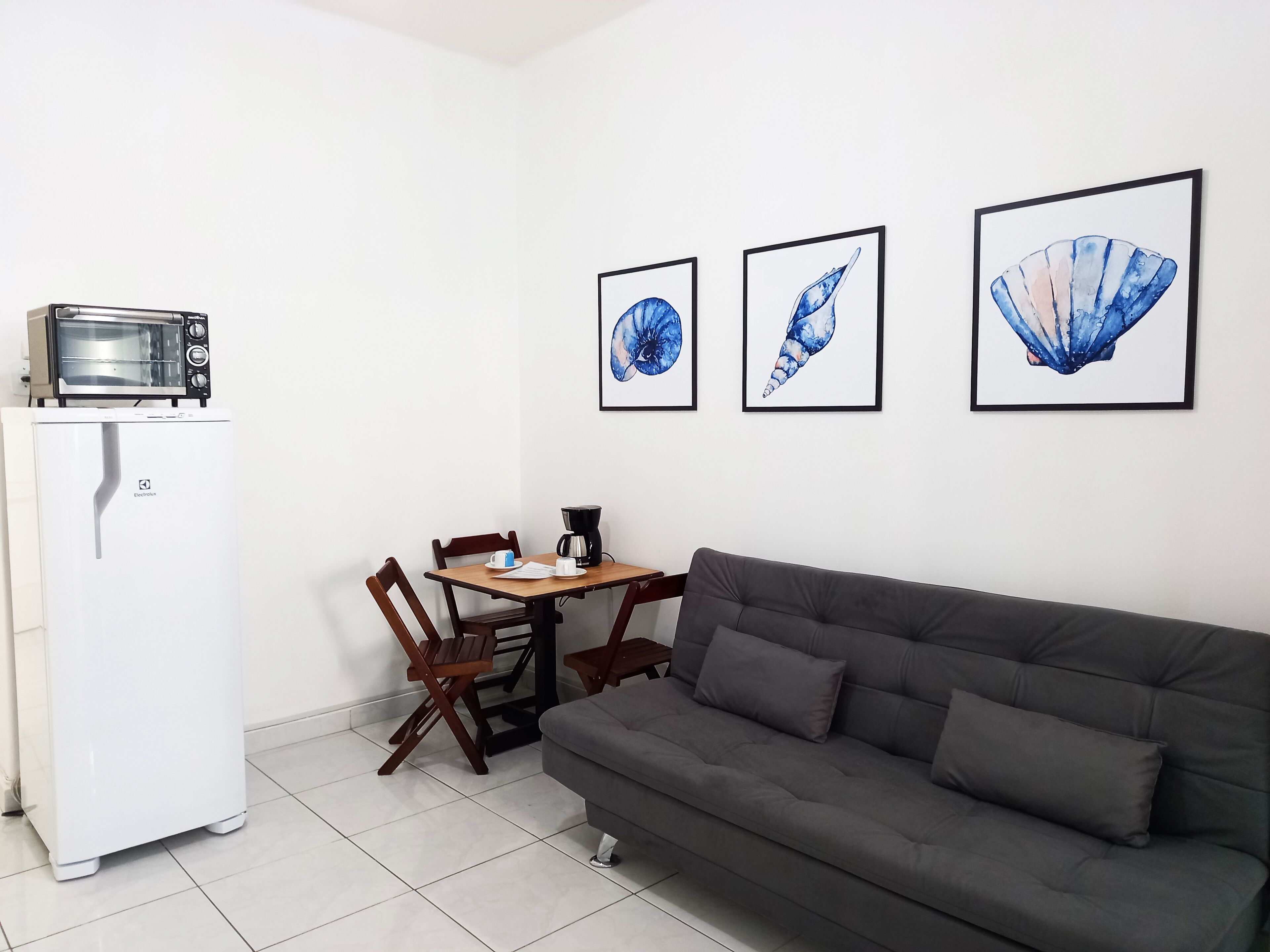 A compact living space with a kitchenette, a dining table, and a sofa.