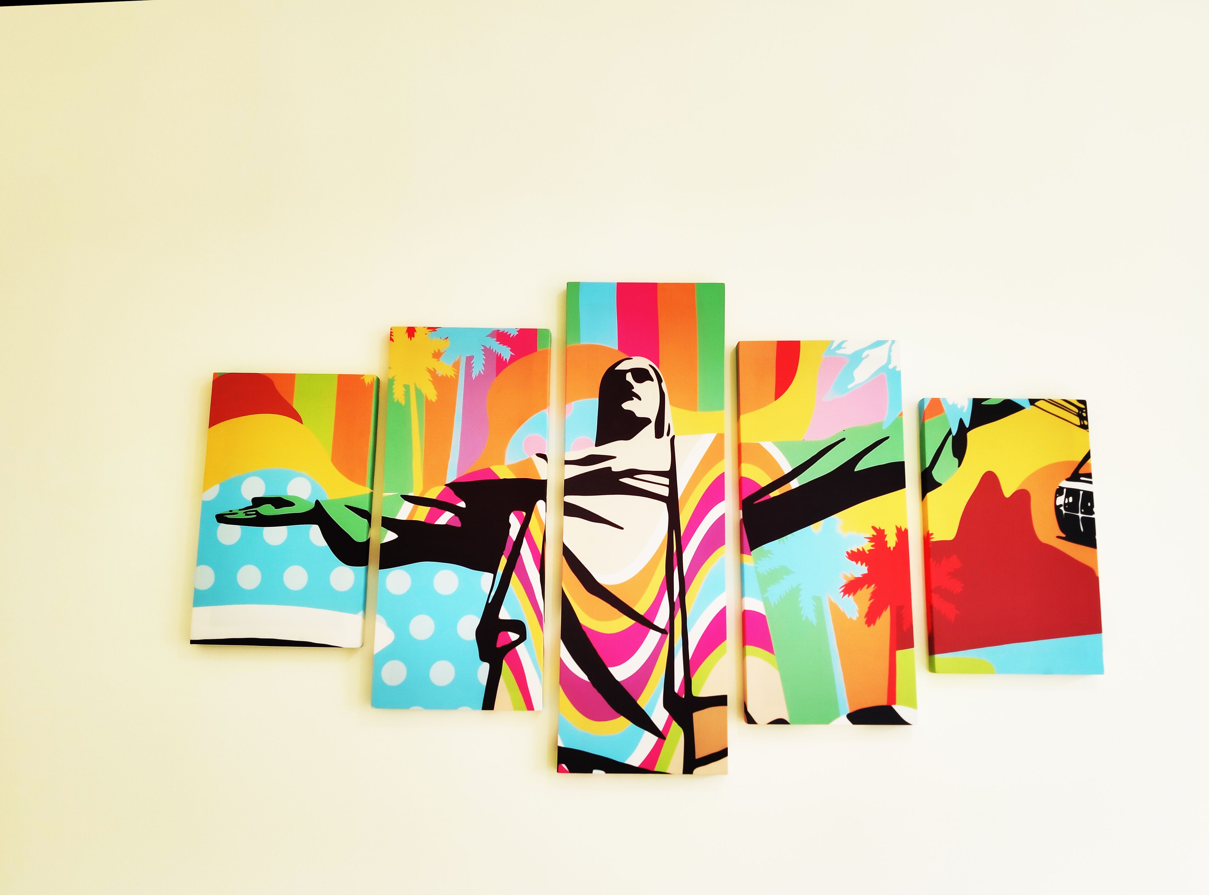 A series of five colorful paintings on a wall.