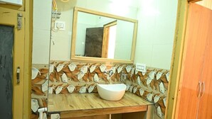 Ein Badezimmer mit einem Holzbadezimmer, einem weißen Waschbecken und einem Spiegel darüber.