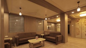 Un soggiorno moderno con due divani, un tavolino da caffè e illuminazione a sospensione.