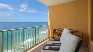 A balcony with a view of the ocean, a table, and two chairs. - 2311-23rd Flr-Outdoor Pool-Poolside Cafe-Hot Tub-Grills-AMAZING Birds Eye VIEW! (Panama City Beach)