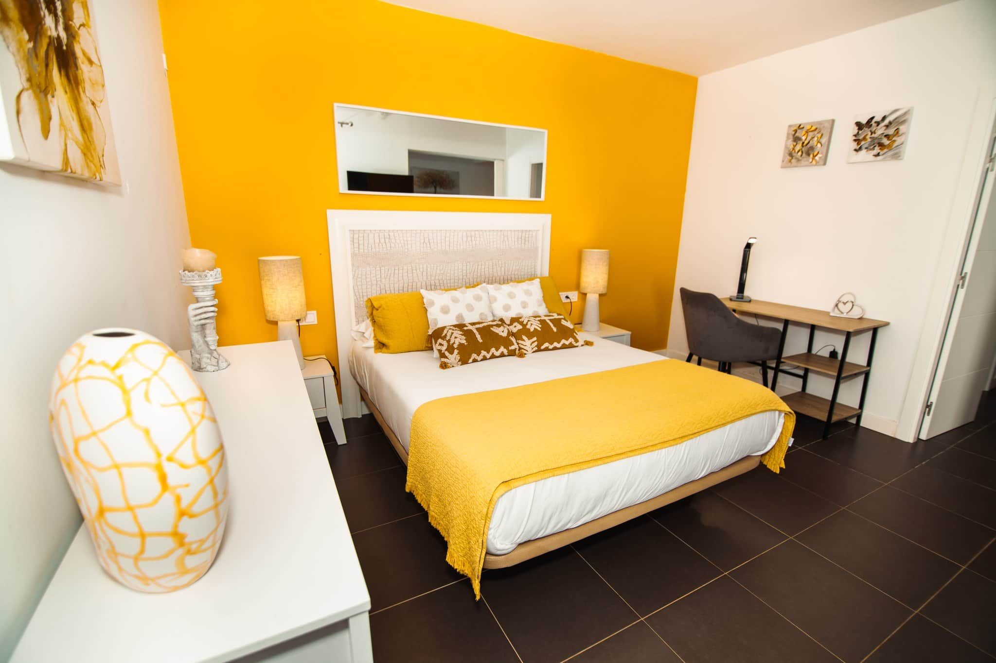 Een hotelkamer met een bed, nachtkastjes, een bureau en een stoel.