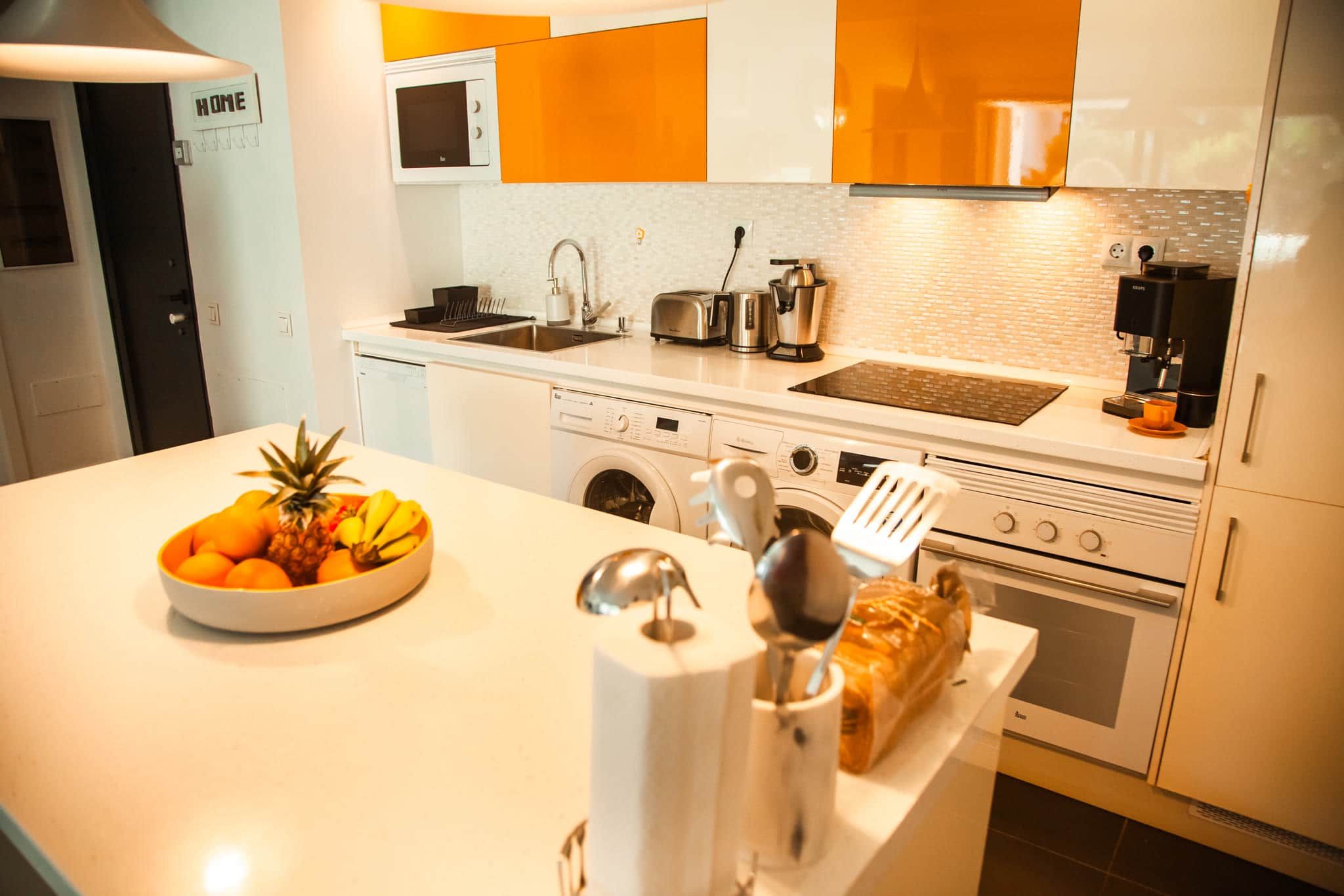 Una cocina moderna equipada con horno empotrado, microondas y cafetera.