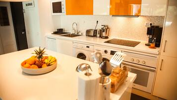 Una cocina moderna equipada con horno empotrado, microondas y cafetera.