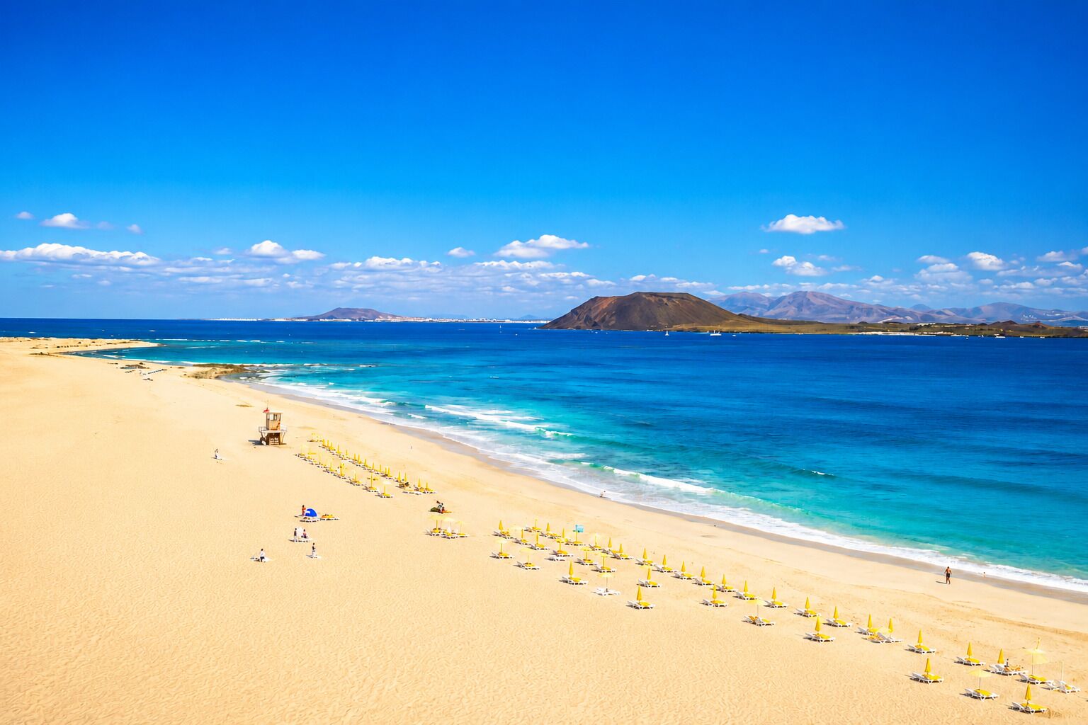 Una playa cerca, sillas reclinables de playa, toallas de playa