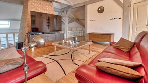 A modern living room with a red leather sofa, a glass coffee table, and a brick fireplace. - Villa 230 M2 With Garden  Lac De Léon And Ocean (Léon)