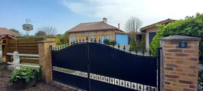 A gated entrance to a property with a traditional house design, a number plaque, and a satellite dish. - Villa 230 M2 With Garden  Lac De Léon And Ocean (Léon)