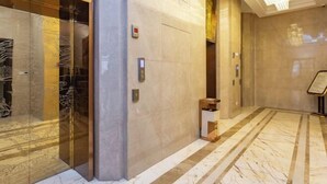 A modern elevator with a control panel and a small wooden counter. - Tianrui Hotel (Yanhe)