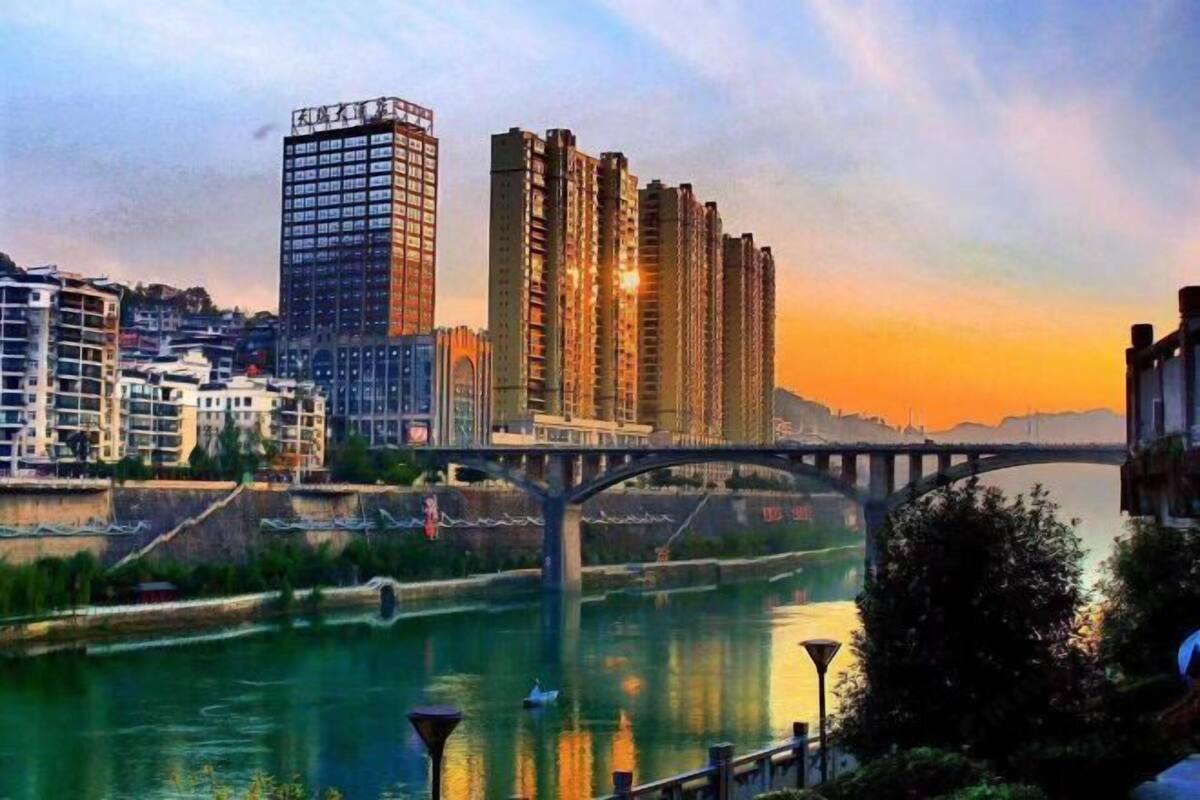 A cityscape with high-rise buildings, a bridge, and a river.