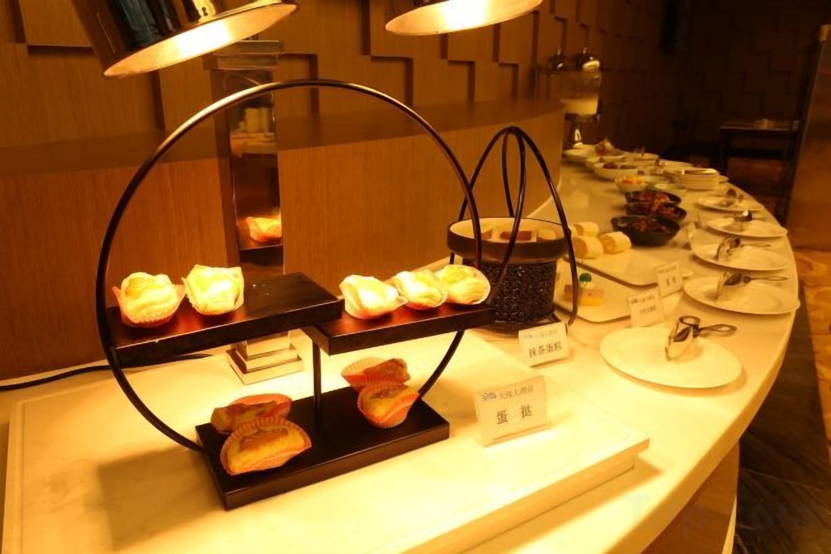 A buffet setup with various food items and a sign indicating a vegetarian option.