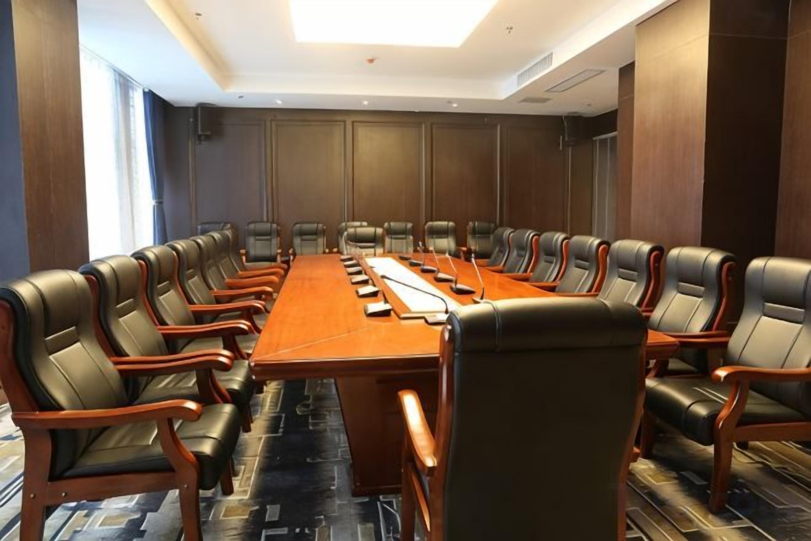 Une salle de conférence avec une longue table et de nombreuses chaises.