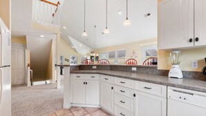 A kitchen with white cabinets, a granite countertop, and a built-in dishwasher. - Anchors Down: Private Pool | Hot Tub | Rec Room (Corolla)